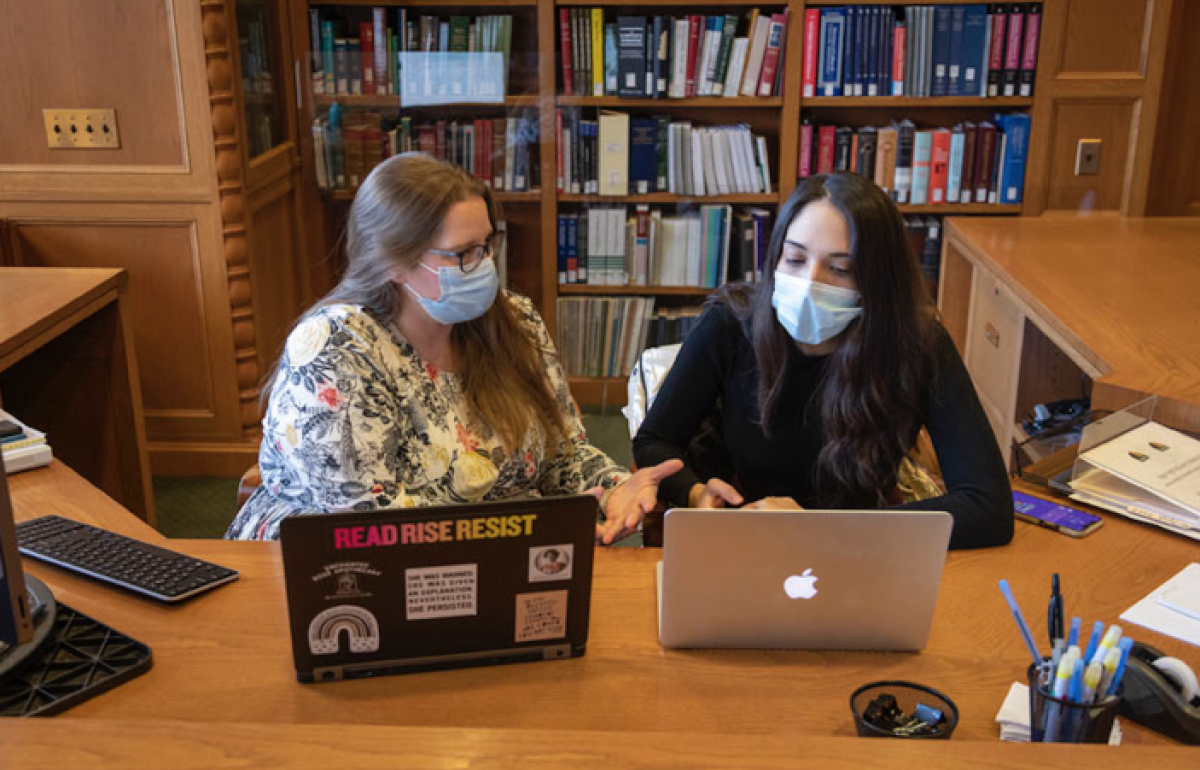 two people collaborating with laptops