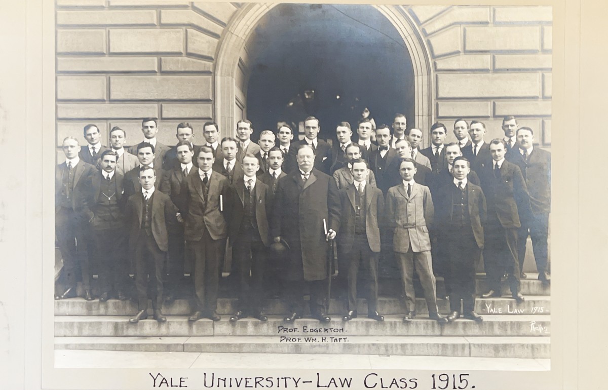 Black and white photograph of President Taft standing in front of three rows of students on building steps