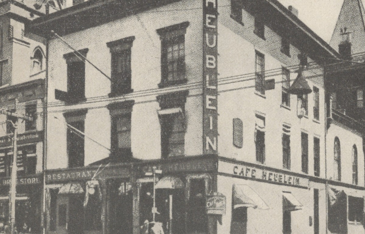 Old photograph of three building on a street corner.