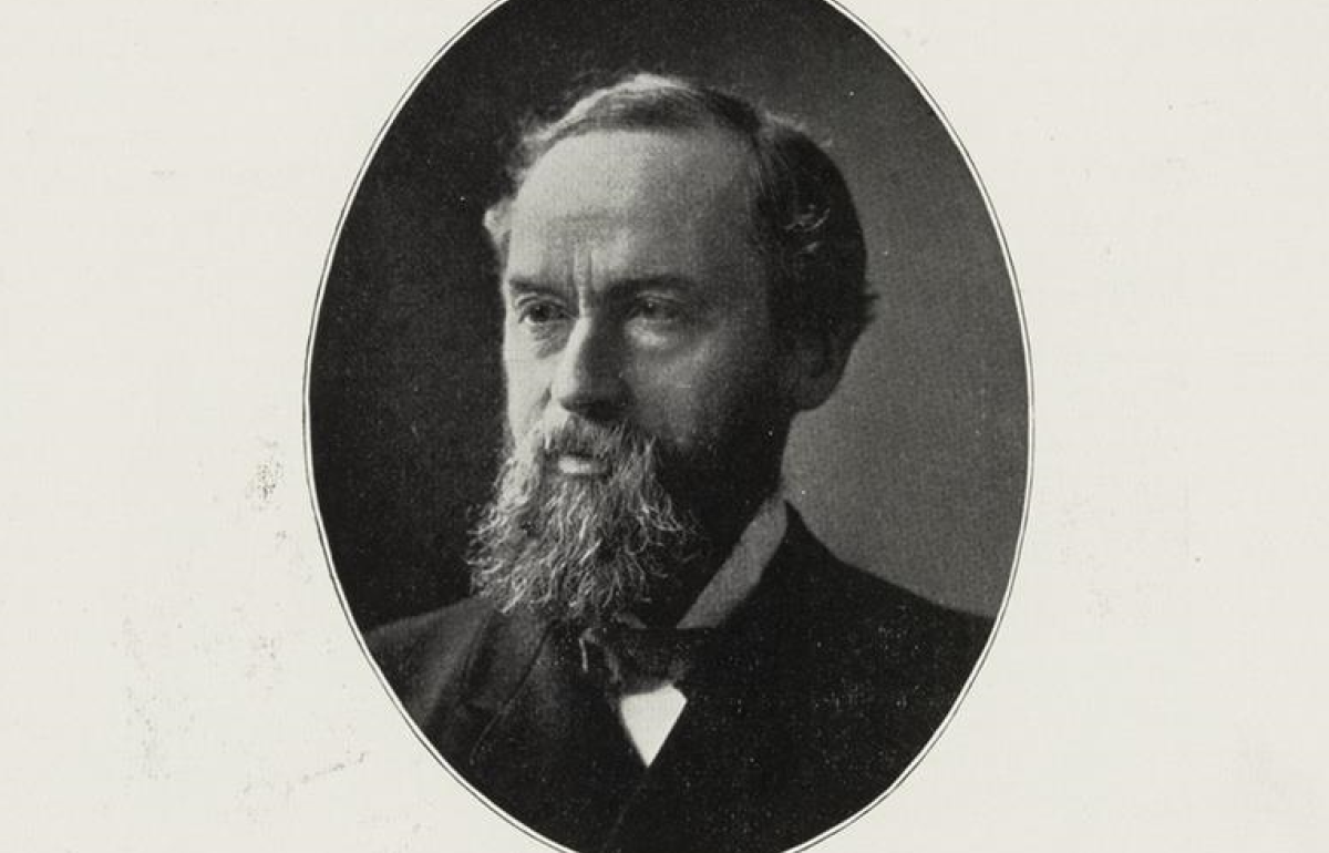 Black and white image in a circular frame of a man with a beard