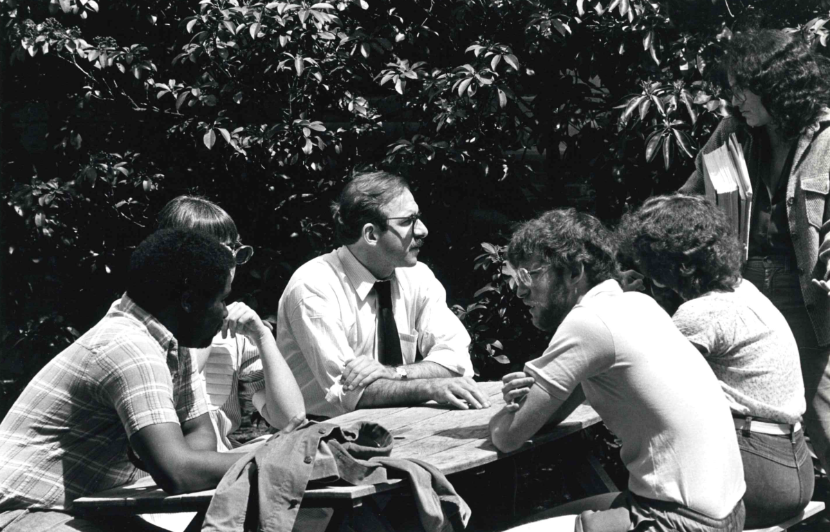 Group of students around a table in a courtyard. 