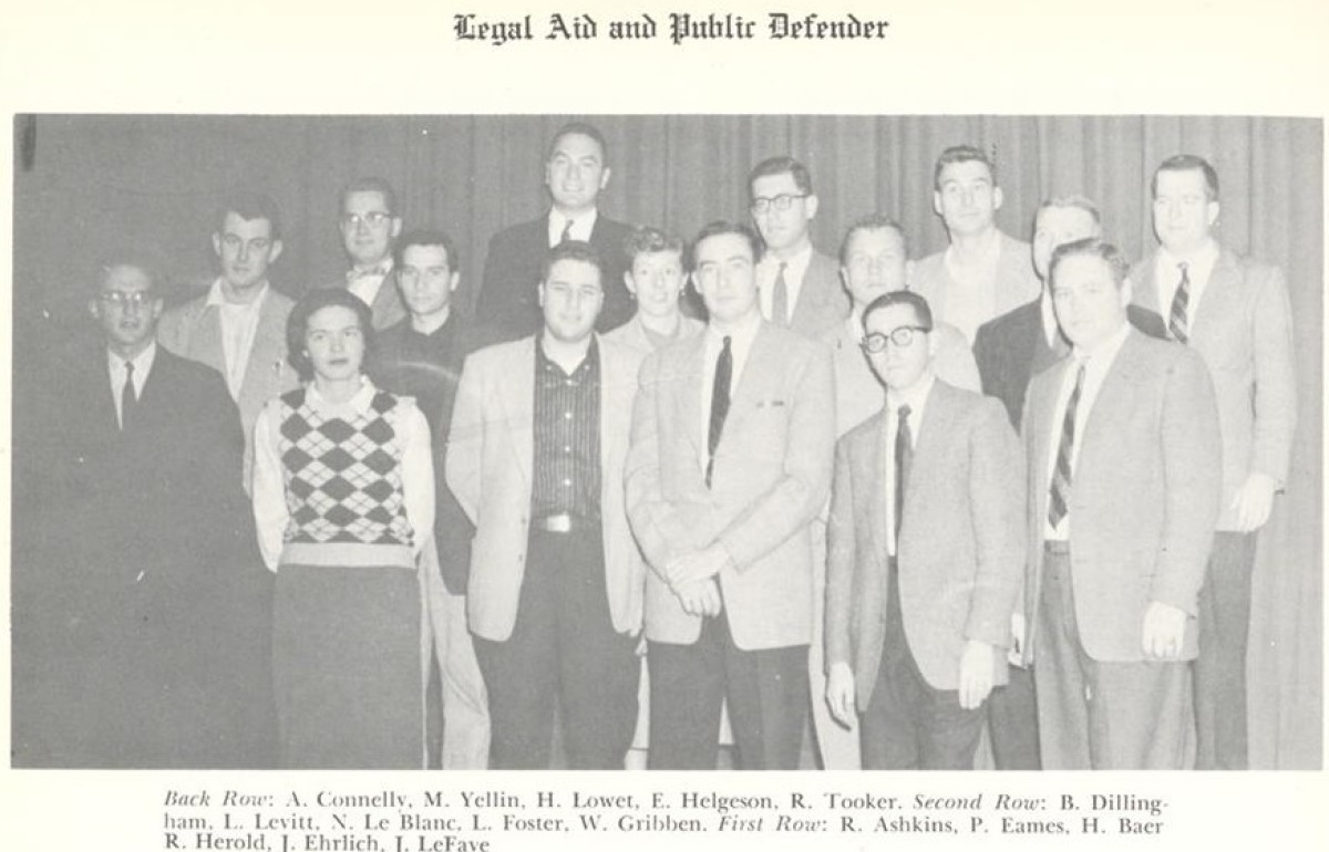 Faded group photograph with many men in suits and a woman in a sweater