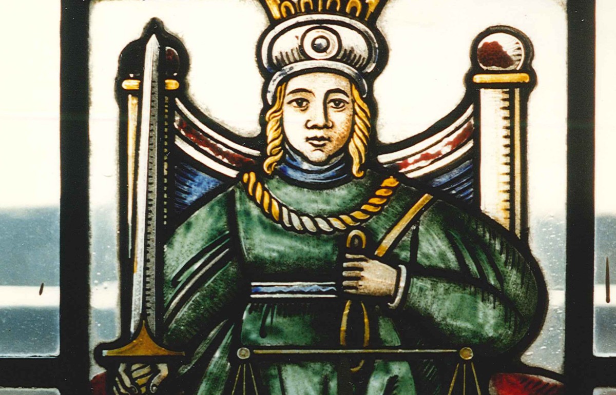 Close up photograph of a stained glass depiction of Justice.